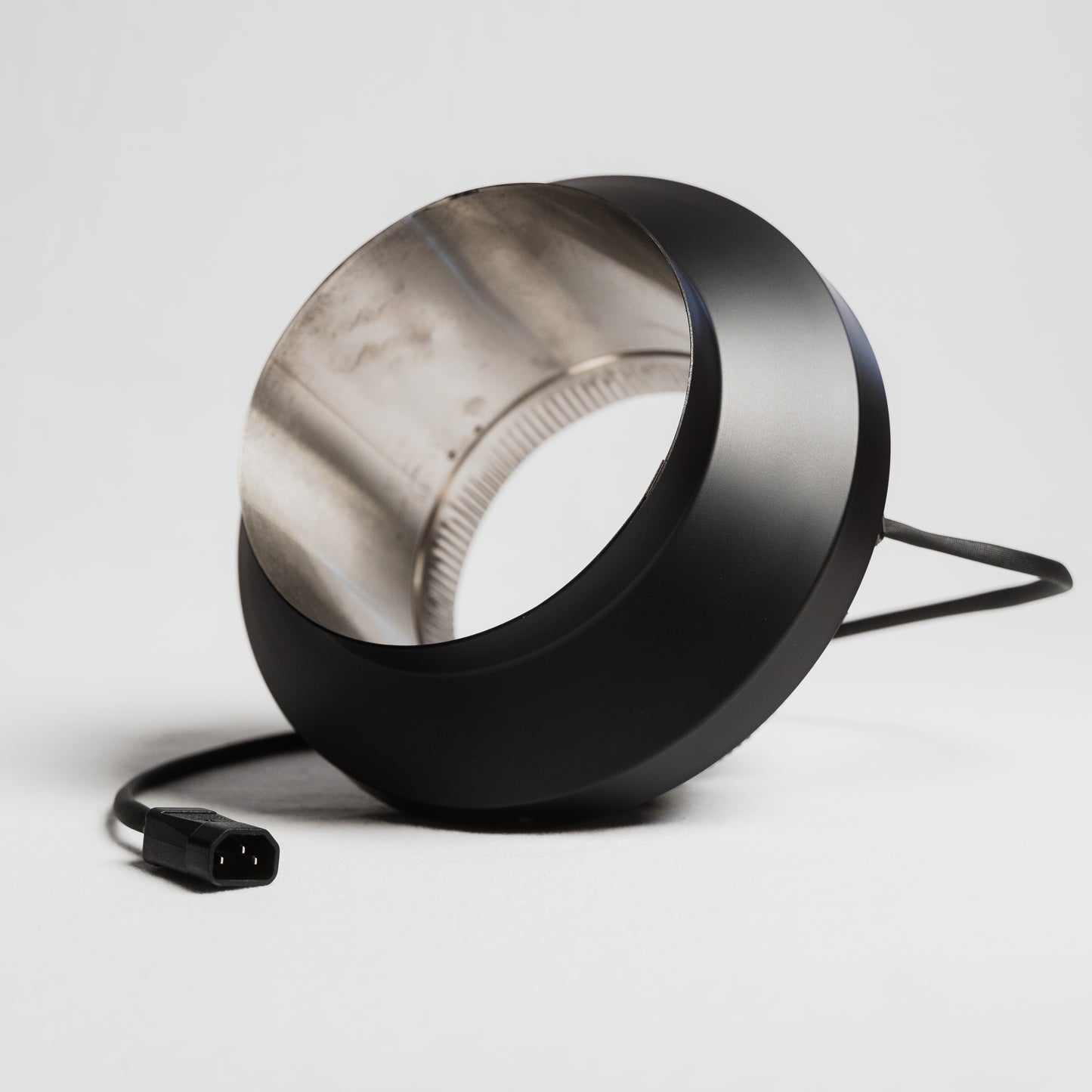 Draw collar for wood burning stoves looking through the pipe. It also has the power cord attached